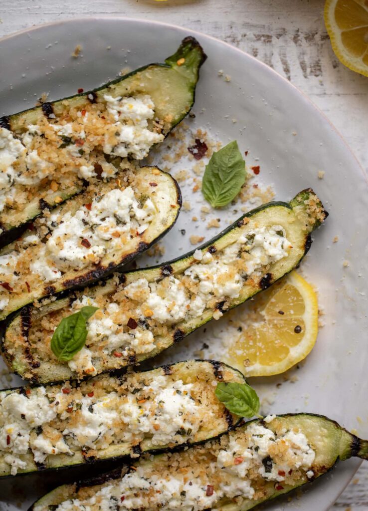 Grilled zucchini boats on the grill with fresh ingredients.