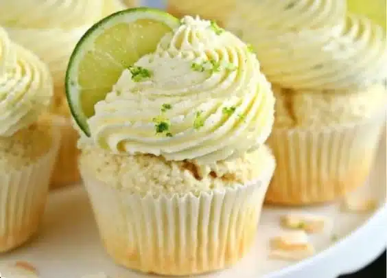 Coconut Lime Cupcakes Recipe 3 Coconut Lime Cupcakes decorated with coconut flakes and lime zest