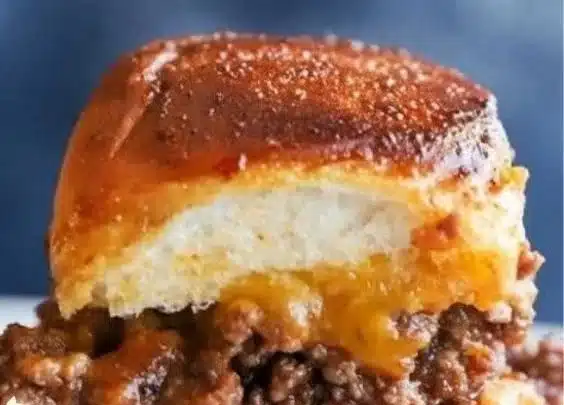 Pull apart cheeseburger sliders served on a platter with toppings.