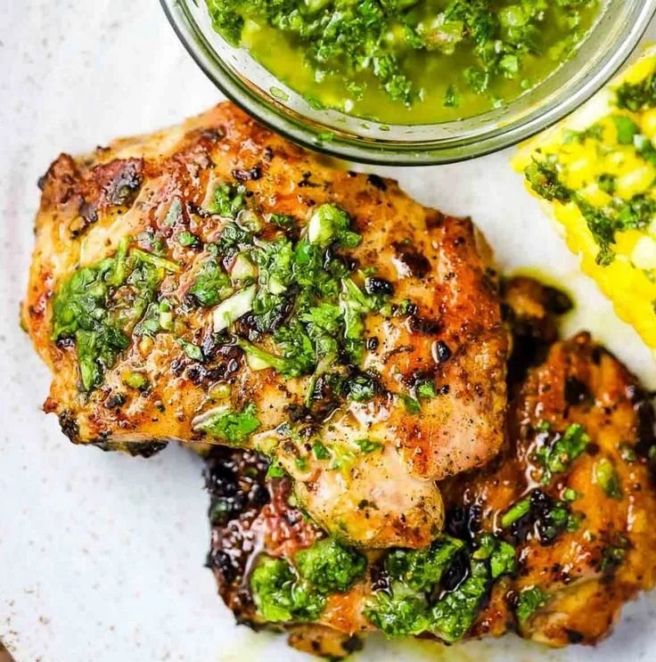 Chimichurri Chicken Thighs 3 Succulent Chimichurri Chicken Thighs garnished with fresh herbs and spices.