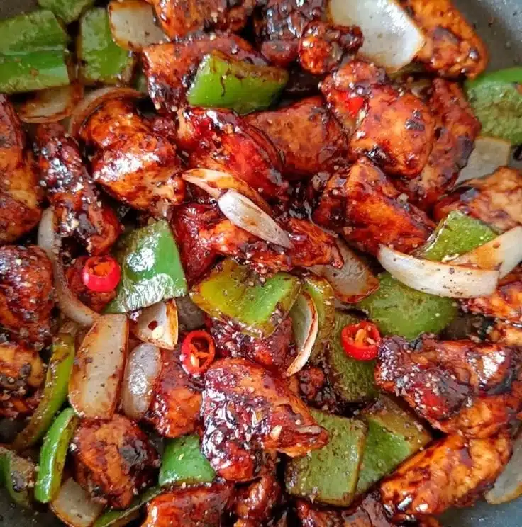 Plate of Easy Black Pepper Chicken garnished with fresh herbs