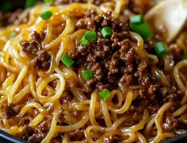 Delicious plate of Mongolian ground beef noodles topped with green onions.