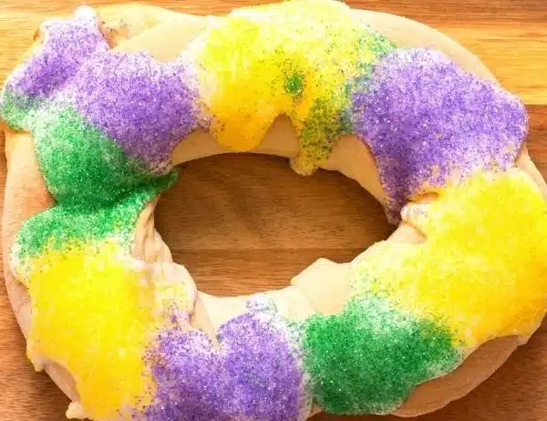 Easy king cake decorated with colorful icing and sugar for Mardi Gras celebration