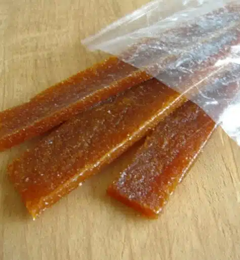 Homemade apricot fruit leather rolls on a wooden table