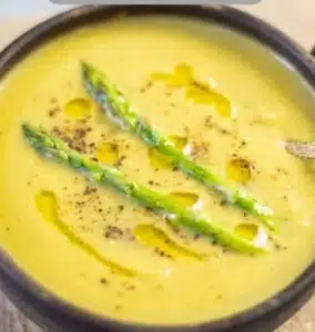 Creamy Instant Pot asparagus soup served in a bowl with fresh asparagus garnish