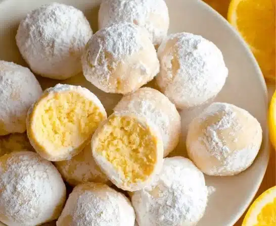 Lemon truffles garnished with lemon zest on a white plate