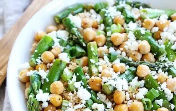 Quinoa salad with asparagus, chickpeas, and fresh vegetables in a bowl.