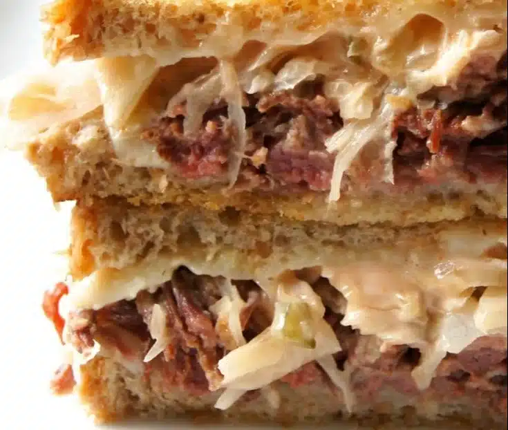 Slow Cooker Reuben Melts with melted cheese and corned beef on toasted bread
