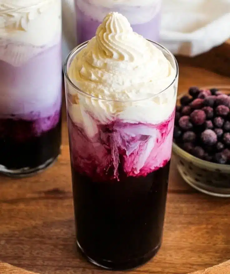 Refreshing sugar free blueberry cream soda in a glass with ice and blueberries