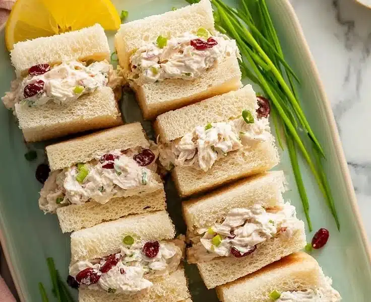Sweet chicken salad tea sandwiches served on a platter with garnishes