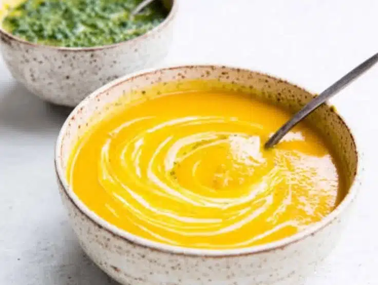 Bowl of Carrot Soup with Chermoula garnished with fresh herbs