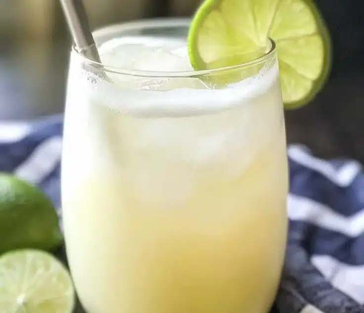 Refreshing Brazilian lemonade in a glass with lime slices and mint leaves