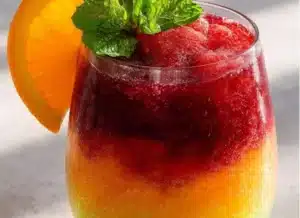 Refreshing Cherry Lime Slush drink in a glass with ice and a lime wedge