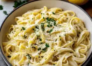 Plate of creamy lemon pasta garnished with fresh herbs