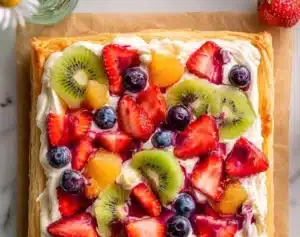 Delicious fruit pizza made with puff pastry, topped with fresh fruits.