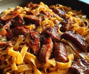 One-Pan Velvety Honey BBQ Steak Fettuccine served with fresh herbs.