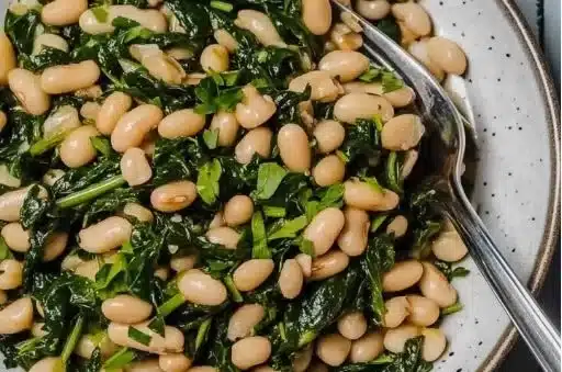 Sautéed garlic spinach with white beans in a vibrant skillet dish