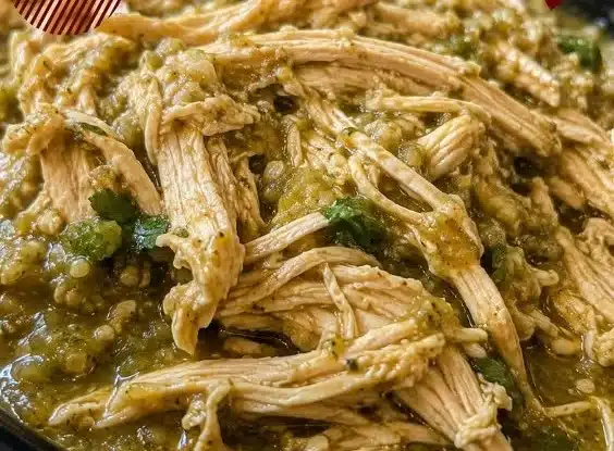 Crock Pot Salsa Verde Chicken cooked in a slow cooker garnished with fresh herbs