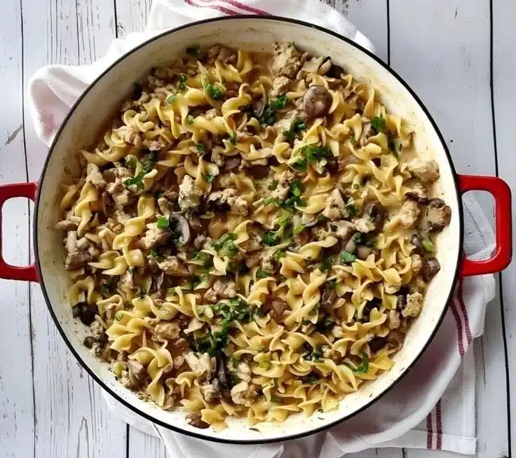 Hearty one pot turkey stroganoff served with noodles and garnished with parsley.